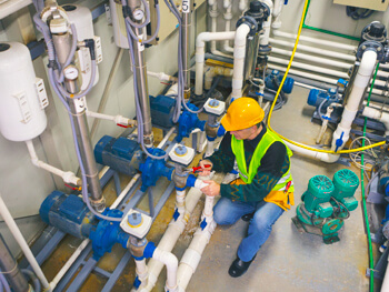 Worker wearing full construction safety gear working in a commercial facility