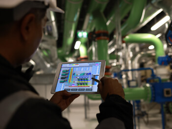 Mechanical worker in construction gear reviewing information on a tablet